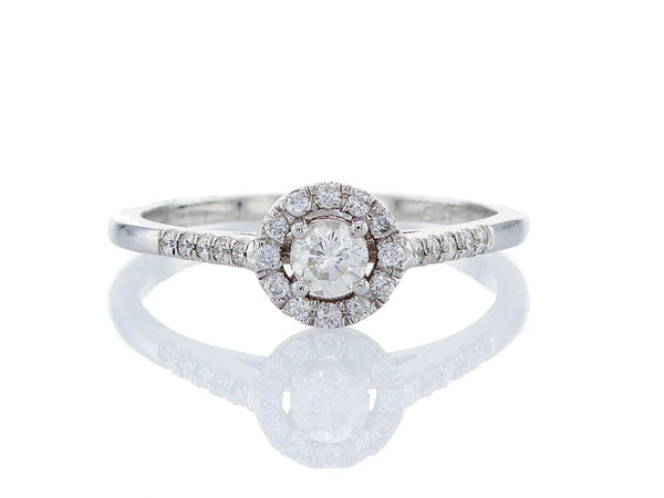 טבעת אירוסין עדינה Fermond Jewelery  טבעת  אירוסין בעלת פרופיל מעוגל עם יהלום טבעי גדול מרכזי ושורת יהלומים מצידיו מרשימה במיוחד, המכילה 22 יהלומים טבעיים במשקל של 0.42 קראט. זהב לבן. הטבעת הזו משלבת את היוקרה והברק של טבעת יהלומים עם האלגנטיות הנצחית, ומציעה יופי ואופנה שמתאימים לכל אירוע.