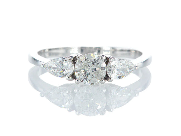 טבעת אילת Fermond Jewelery. טבעת מעוצבת ואלגנטית המציעה יהלום טבעי עגול במרכז, מוקף משני צידיו ביהלומים טבעיים בליטוש טיפה. הטבעת הזו משלבת את היוקרה והברק של טבעת יהלומים עם עיצוב מיוחד ומרשים, ומציעה אלגנטיות ויופי שמתאימים לכל הזדמנות.