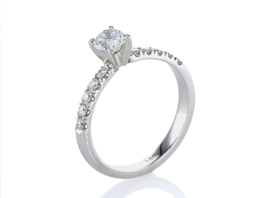 טבעת אירוסין סיוון Fermond Jewelery  טבעת  אירוסין בעלת פרופיל מעוגל עם יהלום טבעי גדול מרכזי ושורת יהלומים מצידיו מרשימה במיוחד, המכילה 10 יהלומים טבעיים במשקל של 0.93 קראט. זהב לבן. הטבעת הזו משלבת את היוקרה והברק של טבעת יהלומים עם האלגנטיות הנצחית, ומציעה יופי ואופנה שמתאימים לכל אירוע.